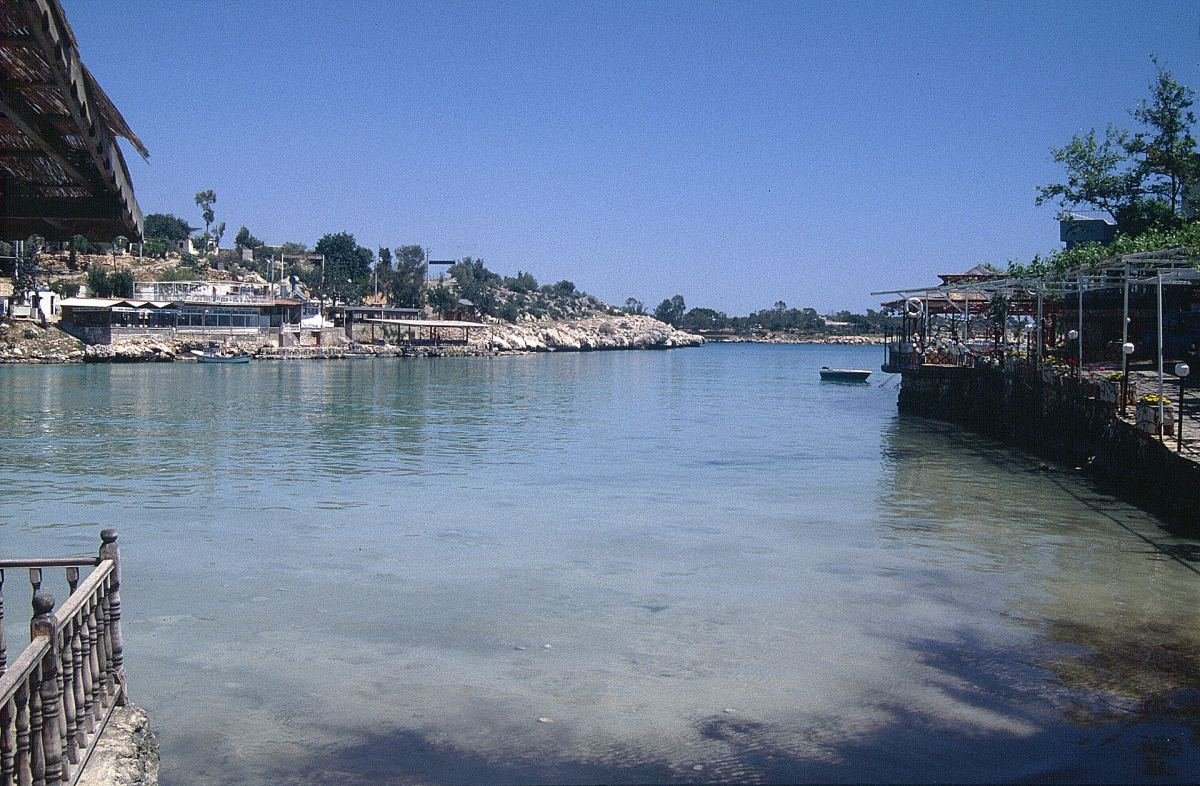 The clear water of Narlıkuyu bay with restaurants along the shore